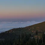 Surreal view of Bakhmaro village houses seemingly floating on a sea of clouds in the Guria mountains, Georgia. Inspiring landscape photography by Georgian artist Zurab Kostava.