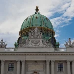 Photograph of the magnificent Karlskirche (St. Charles Church) in Vienna, Austria, showcasing its stunning Baroque architecture, large dome, and flanking columns. Travel photography by Georgian artist Zurab Kostava.