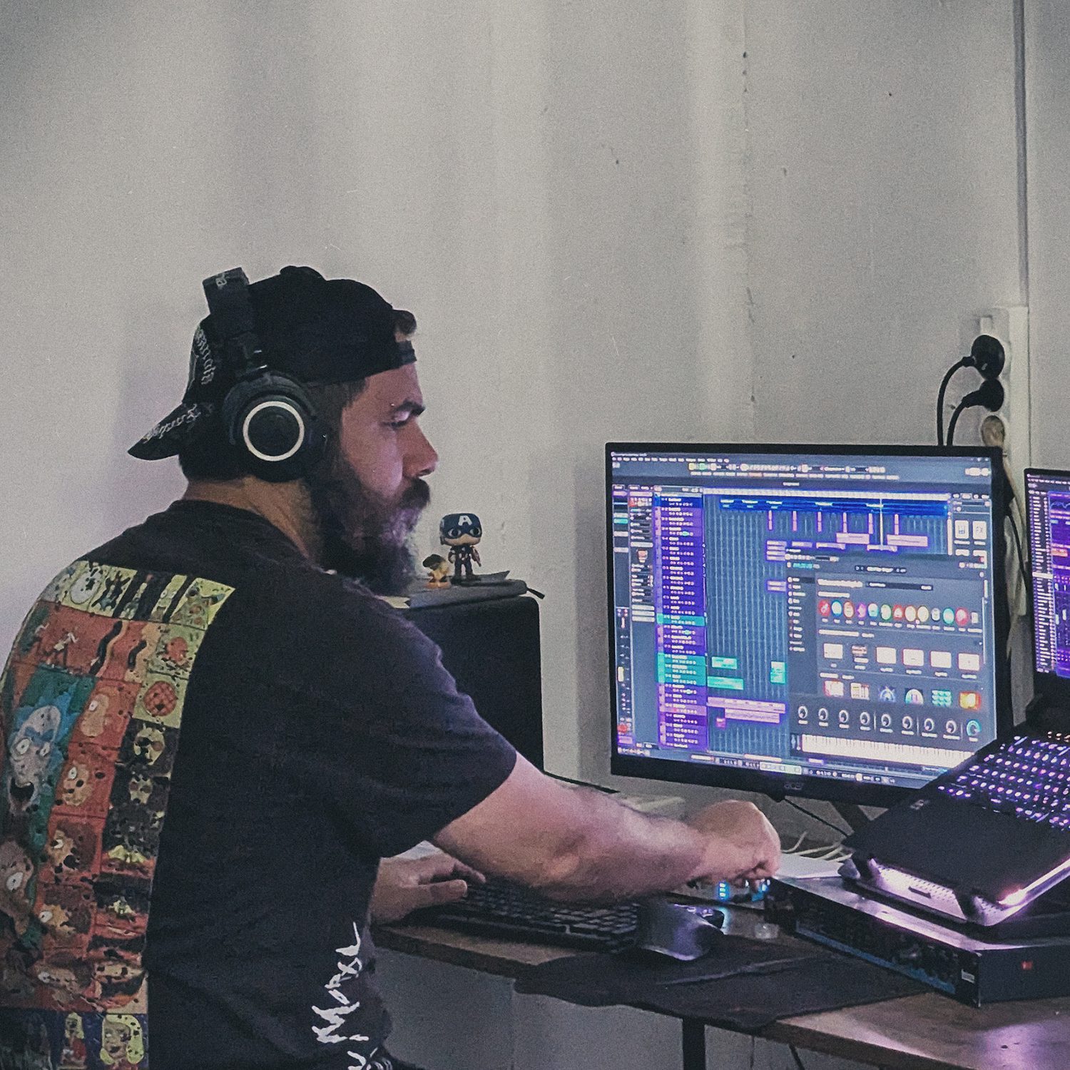 Georgian music producer and composer Zurab Kostava working on a new track in his home studio, using a DAW (Digital Audio Workstation) on his computer.